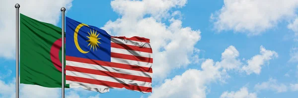 Алжир и флаг Малайзии вместе размахивают ветром против белого облачного голубого неба. Концепция дипломатии, международные отношения . — стоковое фото