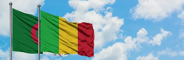 Algieria i Mali flaga machając w wiatr przed białym zachmurzone błękitne niebo razem. Koncepcja dyplomacji, stosunki międzynarodowe. — Zdjęcie stockowe