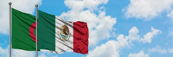 Bandera de Argelia y México ondeando en el viento contra el cielo azul nublado blanco juntos. Concepto diplomático, relaciones internacionales . —  Fotos de Stock