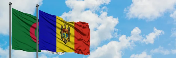 Bandera de Argelia y Moldavia ondeando en el viento contra el cielo azul nublado blanco juntos. Concepto diplomático, relaciones internacionales . — Foto de Stock