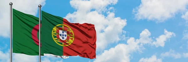 Algerije en Portugal vlag zwaaien in de wind tegen witte bewolkte blauwe hemel samen. Diplomatie concept, internationale betrekkingen. — Stockfoto