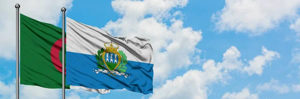 Алжир і Сан-Марино прапора розмахуючи в вітру проти білого хмарного синього неба разом. Концепція дипломатії, міжнародні відносини. — стокове фото