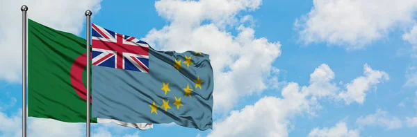 Bandera de Argelia y Tuvalu ondeando en el viento contra el cielo azul nublado blanco juntos. Concepto diplomático, relaciones internacionales . — Foto de Stock