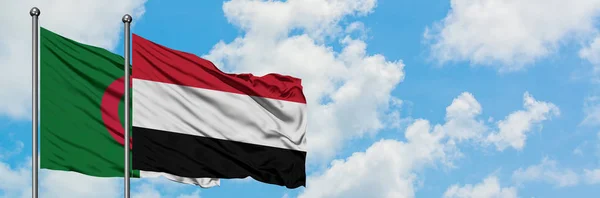 Bandera de Argelia y Yemen ondeando en el viento contra el cielo azul nublado blanco juntos. Concepto diplomático, relaciones internacionales . — Foto de Stock