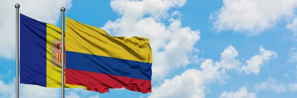 Bandera de Andorra y Colombia ondeando en el viento contra el cielo azul nublado blanco juntos. Concepto diplomático, relaciones internacionales . — Foto de Stock