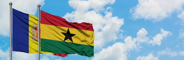 Bandera de Andorra y Ghana ondeando en el viento contra el cielo azul nublado blanco juntos. Concepto diplomático, relaciones internacionales . — Foto de Stock