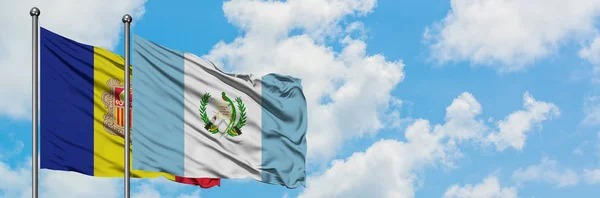 Bandera de Andorra y Guatemala ondeando en el viento contra el cielo azul nublado blanco juntos. Concepto diplomático, relaciones internacionales . — Foto de Stock