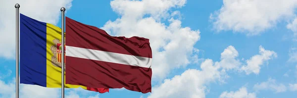 安道尔和拉脱维亚国旗在风中飘扬，与白云蓝天相一起。外交概念、国际关系. — 图库照片