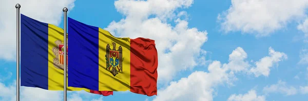 Bandera de Andorra y Moldavia ondeando en el viento contra el cielo azul nublado blanco juntos. Concepto diplomático, relaciones internacionales . — Foto de Stock