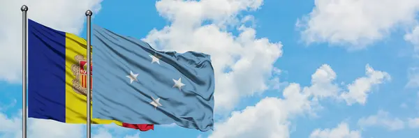 Bandera de Andorra y Micronesia ondeando en el viento contra el cielo azul nublado blanco juntos. Concepto diplomático, relaciones internacionales . — Foto de Stock