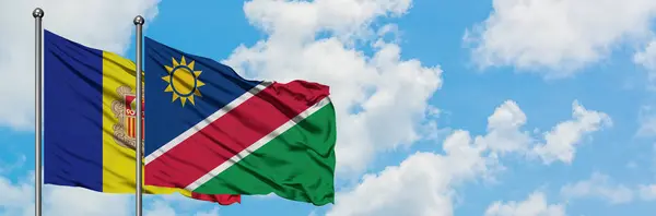 Andorre et la Namibie drapeau agitant dans le vent contre ciel bleu nuageux blanc ensemble. Concept de diplomatie, relations internationales . — Photo