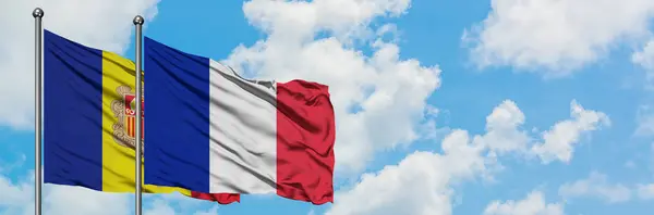 Andorra és Reunion zászló integetett a szél ellen, fehér felhős kék ég együtt. Diplomáciai koncepció, nemzetközi kapcsolatok. — Stock Fotó