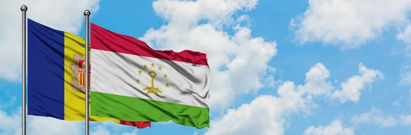 Bandera de Andorra y Tayikistán ondeando en el viento contra el cielo azul nublado blanco juntos. Concepto diplomático, relaciones internacionales . — Foto de Stock
