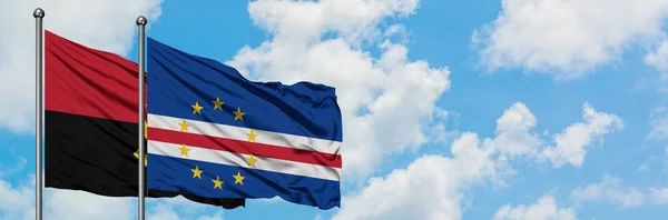 Bandera de Angola y Cabo Verde ondeando en el viento contra el cielo azul nublado blanco juntos. Concepto diplomático, relaciones internacionales . — Foto de Stock