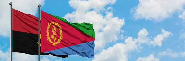 Angola och Eritrea flagga vifta i vinden mot vit grumlig blå himmel tillsammans. Diplomatisk koncept, internationella relationer. — Stockfoto