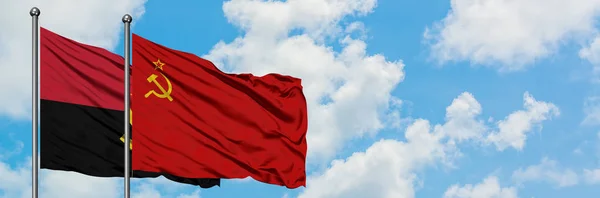 Angola e a bandeira da União Soviética agitando no vento contra o céu azul nublado branco juntos. Conceito de diplomacia, relações internacionais . — Fotografia de Stock