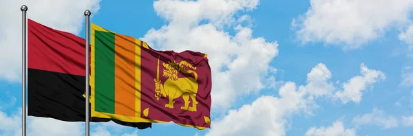 Angola und sri lanka fahne wehen gemeinsam im wind vor weißem wolkenblauem himmel. Diplomatie-Konzept, internationale Beziehungen. — Stockfoto