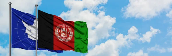 Bandera de la Antártida y Afganistán ondeando en el viento contra el cielo azul nublado blanco juntos. Concepto diplomático, relaciones internacionales . — Foto de Stock
