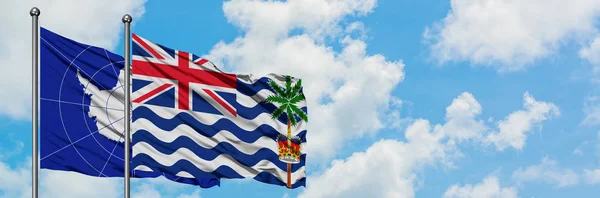 Antarctica and British Indian Ocean Territory flag waving in the wind against white cloudy blue sky together. Diplomacy concept, international relations. — Stock Photo, Image