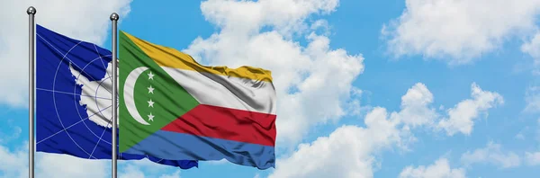 Bandera de la Antártida y las Comoras ondeando en el viento contra el cielo azul nublado blanco juntos. Concepto diplomático, relaciones internacionales . — Foto de Stock