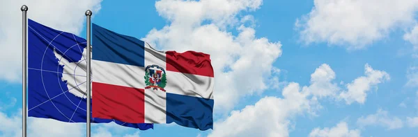 Antarctica en Dominicaanse Republiek vlag zwaaien in de wind tegen witte bewolkte blauwe hemel samen. Diplomatie concept, internationale betrekkingen. — Stockfoto