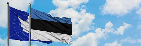 Bandera de la Antártida y Estonia ondeando en el viento contra el cielo azul nublado blanco juntos. Concepto diplomático, relaciones internacionales . — Foto de Stock