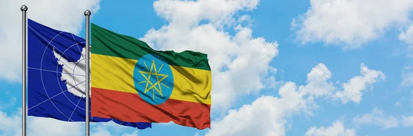 一緒に白い曇り青い空に対して風に振る南極とエチオピアの旗。外交概念、国際関係. — ストック写真