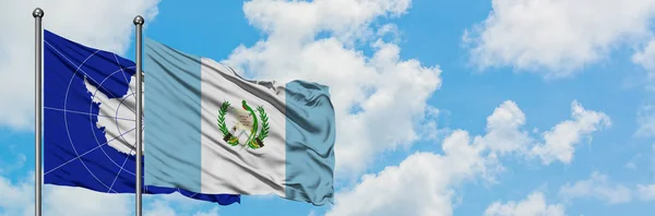 Bandera de la Antártida y Guatemala ondeando en el viento contra el cielo azul nublado blanco juntos. Concepto diplomático, relaciones internacionales . —  Fotos de Stock