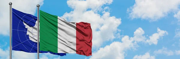 Bandera de la Antártida e Italia ondeando en el viento contra el cielo azul nublado blanco juntos. Concepto diplomático, relaciones internacionales . — Foto de Stock