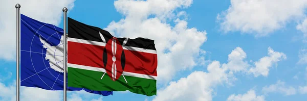 Bandera de la Antártida y Kenia ondeando en el viento contra el cielo azul nublado blanco juntos. Concepto diplomático, relaciones internacionales . —  Fotos de Stock