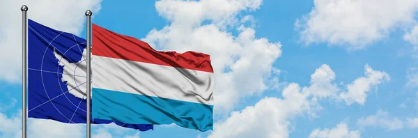 Antarktyda i Luksemburg flaga machając w wiatr przed białym zachmurzone błękitne niebo razem. Koncepcja dyplomacji, stosunki międzynarodowe. — Zdjęcie stockowe