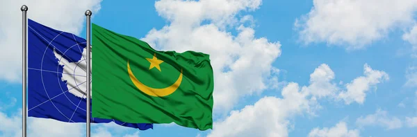 Bandera de la Antártida y Mauritania ondeando en el viento contra el cielo azul nublado blanco juntos. Concepto diplomático, relaciones internacionales . — Foto de Stock