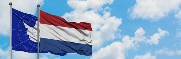 Antarktyda i flaga Holandii machając w wiatr przed białym zachmurzone błękitne niebo razem. Koncepcja dyplomacji, stosunki międzynarodowe. — Zdjęcie stockowe
