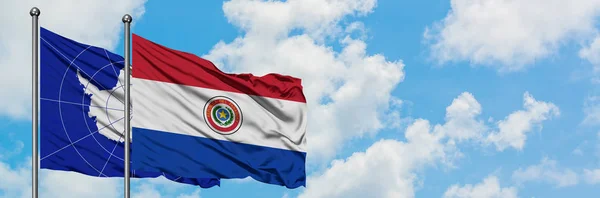 Antarctica en Paraguay vlag zwaaien in de wind tegen witte bewolkte blauwe hemel samen. Diplomatie concept, internationale betrekkingen. — Stockfoto