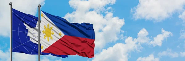 Bandera de la Antártida y Filipinas ondeando en el viento contra el cielo azul nublado blanco juntos. Concepto diplomático, relaciones internacionales . —  Fotos de Stock