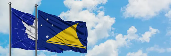 Antarctica and Tokelau flag waving in the wind against white cloudy blue sky together. Diplomacy concept, international relations. — Stock Photo, Image