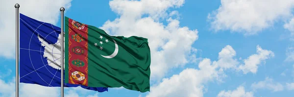 Bandera de la Antártida y Turkmenistán ondeando en el viento contra el cielo azul nublado blanco juntos. Concepto diplomático, relaciones internacionales . — Foto de Stock