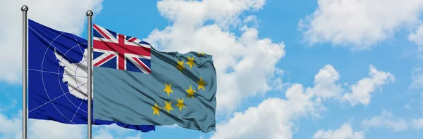 Bandera de la Antártida y Tuvalu ondeando en el viento contra el cielo azul nublado blanco juntos. Concepto diplomático, relaciones internacionales . — Foto de Stock