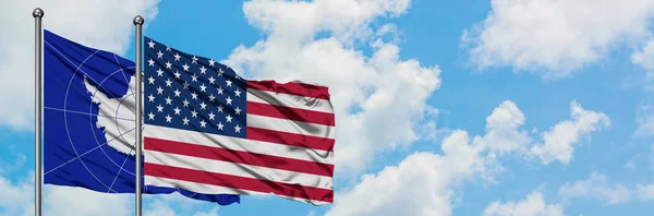 A Antártida e a bandeira dos Estados Unidos agitando no vento contra o céu azul nublado branco juntos. Conceito de diplomacia, relações internacionais . — Fotografia de Stock