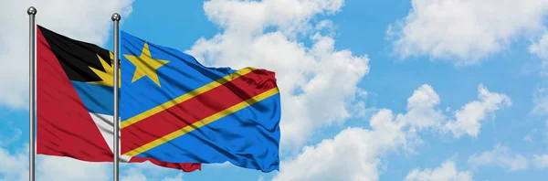 Antigua y Barbuda con la bandera del Congo ondeando en el viento contra el cielo azul nublado blanco juntos. Concepto diplomático, relaciones internacionales . — Foto de Stock