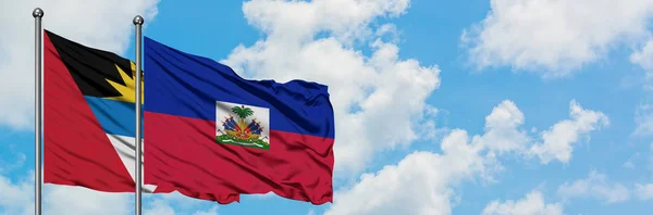Antigua ve Barbuda Haiti bayrağı ile birlikte beyaz bulutlu mavi gökyüzüne karşı rüzgarda sallayarak. Diplomasi kavramı, uluslararası ilişkiler. — Stok fotoğraf