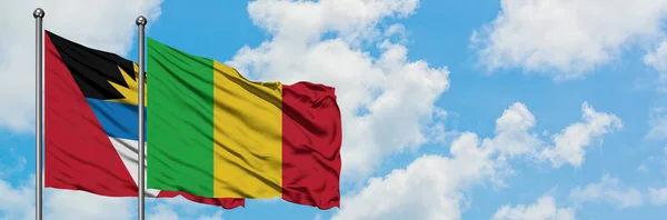 Antígua e Barbuda com a bandeira do Mali agitando no vento contra o céu azul nublado branco juntos. Conceito de diplomacia, relações internacionais . — Fotografia de Stock