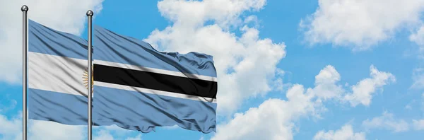 Argentina and Botswana flag waving in the wind against white cloudy blue sky together. Diplomacy concept, international relations. — Stock Photo, Image