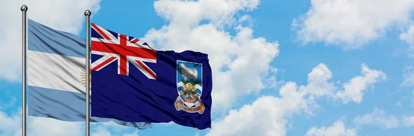 Bandera de Argentina e Islas Malvinas ondeando en el viento contra el cielo azul nublado blanco juntos. Concepto diplomático, relaciones internacionales . — Foto de Stock