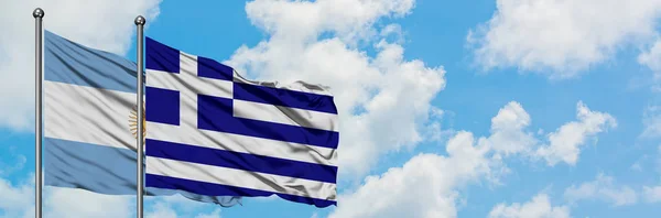 Argentinië en Griekenland vlag zwaaien in de wind tegen witte bewolkte blauwe hemel samen. Diplomatie concept, internationale betrekkingen. — Stockfoto