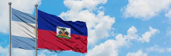 Argentina and Haiti flag waving in the wind against white cloudy blue sky together. Diplomacy concept, international relations. — Stock Photo, Image