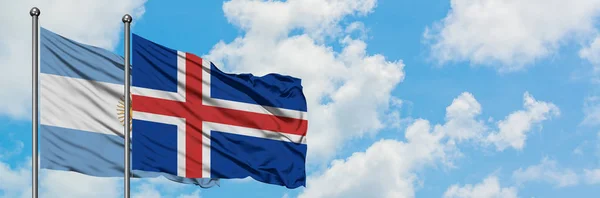 Аргентина та Ісландія прапор розмахуючи в вітру проти білого хмарного синього неба разом. Концепція дипломатії, міжнародні відносини. — стокове фото