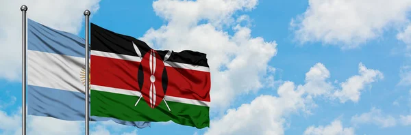 Argentína és Kenya zászló integetett a szél ellen, fehér felhős kék ég együtt. Diplomáciai koncepció, nemzetközi kapcsolatok. — Stock Fotó