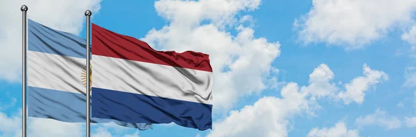 Аргентина та Нідерланди прапор розмахував вітром проти білого хмарного синього неба разом. Концепція дипломатії, міжнародні відносини. — стокове фото