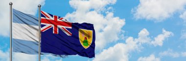 Arjantin ve Turks ve Caicos Adaları bayrağı birlikte beyaz bulutlu mavi gökyüzüne karşı rüzgarsal sallayarak. Diplomasi kavramı, uluslararası ilişkiler.
